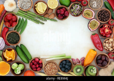 Super sano cibo del bordo dello sfondo su pergamena con pesce fresco, verdure, frutta, semi, cereali, noci, erbe aromatiche e spezie. Foto Stock