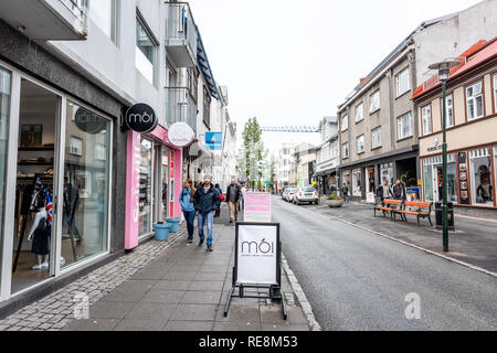 Reykjavik, Islanda - 19 Giugno 2018: strada bagnata strada marciapiede in centro e seguire le indicazioni per moi durante nuvoloso giorno di estate Foto Stock