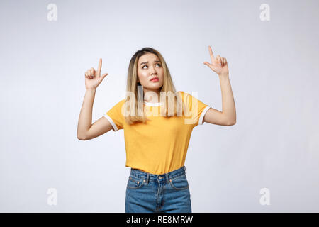 Giovane donna asiatica guardando arrabbiato e triste mentre puntare il dito in telecamera isolata contro uno sfondo bianco. Foto Stock