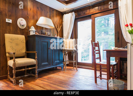 Il beige panno lino poltroncina imbottita, mobilia di legno antico armadio e scrivania in alcova all'interno di un nuovo stile Hampton home Foto Stock