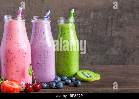 Frullati colorati in bottiglie, sana detox vitamina dieta vegana o bevande con frutta, bacche e cannucce. close up Foto Stock