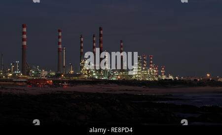 Foto interessante di una raffineria di petrolio dal mare di notte Foto Stock