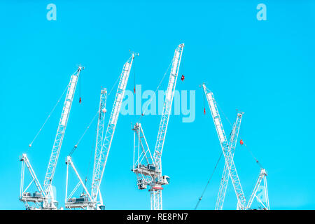 Londra, UK Tamigi costruzione molte gru bianca closeup isolata contro estiva soleggiata turchese blu cielo industriale paesaggio urbano Foto Stock