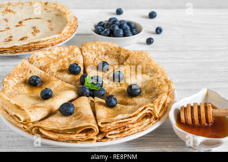 Pila di frittelle o crepes con mirtilli freschi, acero e sciroppo di menta. close up. Russkie bliny Foto Stock