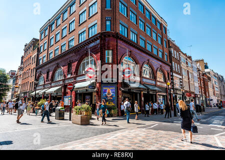 London, Regno Unito - 26 Giugno 2018: Street in Covent garden in estate con edifici in mattoni e shopping al dettaglio segno per la metropolitana stazione metropolitana e ma Foto Stock