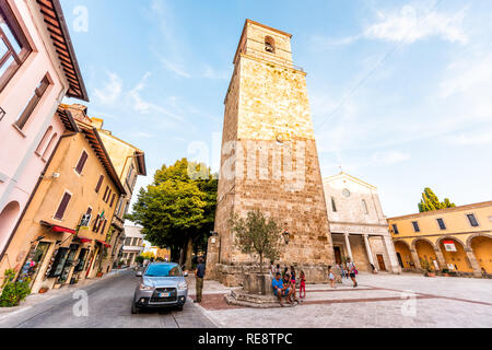 Chiusi, Italia - 25 agosto 2018: Via Piazza con il campanile di una chiesa nel piccolo villaggio di città in Umbria durante il giorno con le persone e architettura di pietra Foto Stock