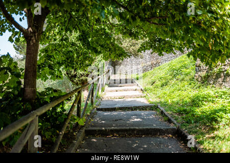 Val D'Orcia campagna in Toscana, Italia con vuoto percorso stradale passi nel parco giardino di Montalcino nella piccola città villaggio con nessuno Foto Stock