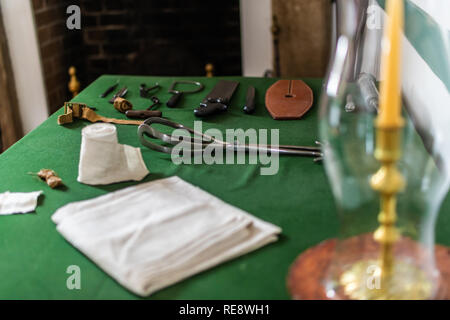 Vintage antichi strumenti medicali visualizzati su una tabella in una storica sala esame Foto Stock