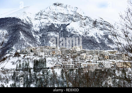 Vista aerea della bella coperta di neve villaggio di Opi con montagne innevate sullo sfondo. Foto Stock