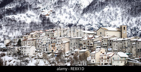 Vista aerea della bella coperta di neve villaggio di Opi con montagne innevate sullo sfondo. Foto Stock