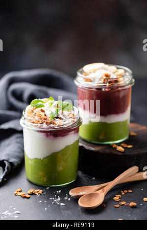 Layered acai frullato di avocado o budino di chia in barattolo. Mangiare sano, dieta e detox e cibo vegetariano concept Foto Stock