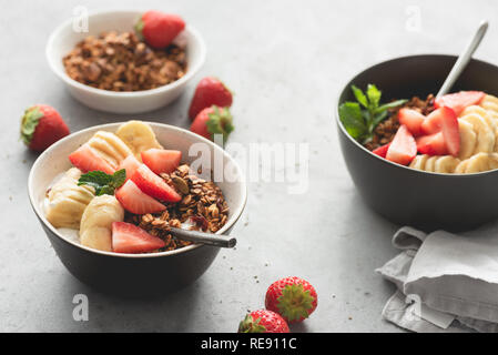 Frutta con cereali e lo yogurt in un recipiente per la prima colazione. La luce del mattino. Concetto di mangiare sano, uno stile di vita sano Foto Stock