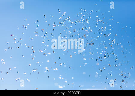 Gocce d'acqua in aria contro il cielo Foto Stock