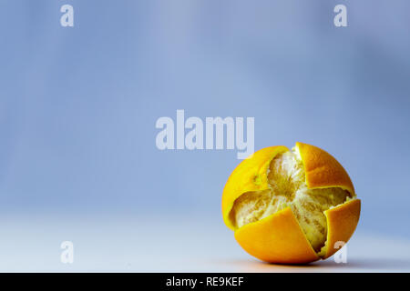 Tutta arancione su sfondo blu con buccia tagliate vicino. Foto Stock