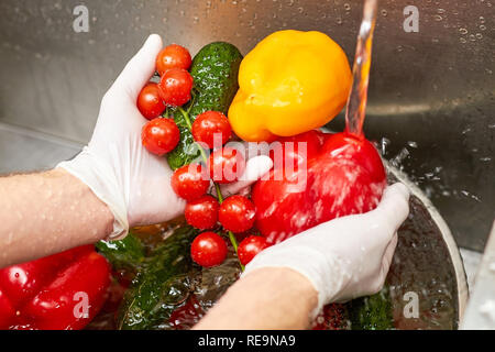 Chiudere il lavaggio della verdura sotto acqua corrente del rubinetto. Ortaggi freschi il lavaggio con acqua fluente nel lavello. Foto Stock