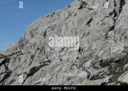 Popolare percorso in Aiguilles Rouges che conduce fino al Col de la Glieres salì da sola donna walker utilizzando il cavo della ringhiera per il supporto tecnico su roccia f Foto Stock