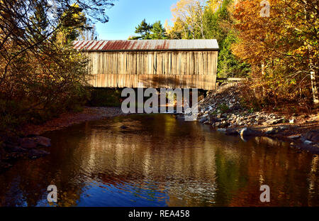 Un lato orizzontale vista dell'iconica coperta in legno ponte che attraversa la trota torrente a Urney vicino a poli Mountain New Brunswick Canada Foto Stock