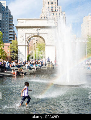 Una ragazza schizzi attraverso Washington Square fontana nella città di New York. Foto Stock