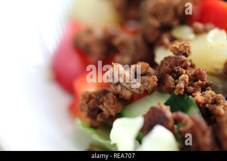 Foto macro di una deliziosa casa insalata. Questa insalata sana include alcune carni macinate, insalata, dadi, ananassi, peperoni rossi e più. Yum! Foto Stock