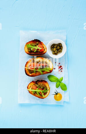 Toast con salmone affumicato, rucola, pesto e capperi laici piatta Foto Stock