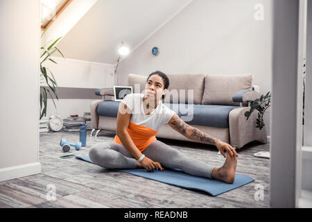 African American donna confortevole da indossare abbigliamento sportivo con elementi di colore arancione Foto Stock