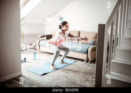 Gioioso donna sportive di trascorrere del tempo a casa Foto Stock