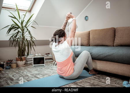 Dai capelli scuri donna alzando le mani durante l'oscillazione premere Foto Stock