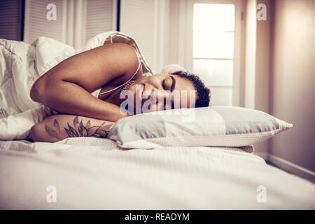 Sorridente americano africano donna dorme pacificamente su mani collegato Foto Stock