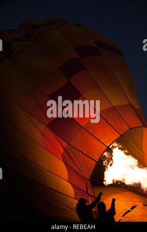 In mongolfiera ad aria calda essendo riempito in la mattina molto presto ancora buio ma le fiamme luminose Foto Stock