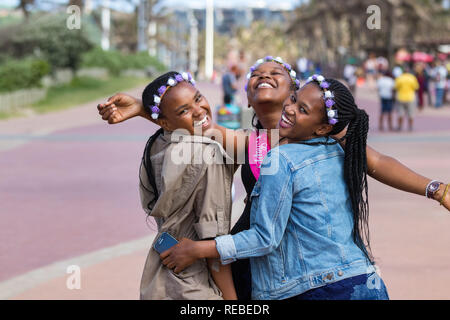 Durban, Sud Africa - Gennaio 07th, 2019: tre bellissime black giovani donne ridere e festeggiare un compleanno all'aperto a Durban, Sud Africa. Foto Stock