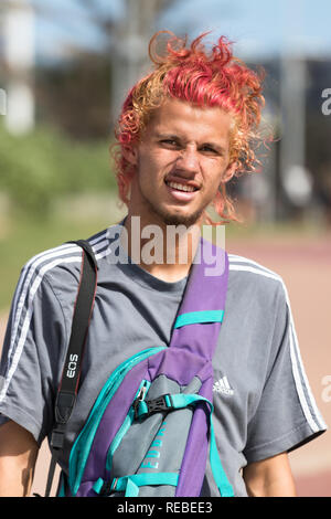 Durban, Sud Africa - Gennaio 07th, 2019: Ritratto di una giovane uomo caucasico con capelli biondi tinti e di colore rosso guardando la fotocamera all'aperto a Durban, in modo Foto Stock