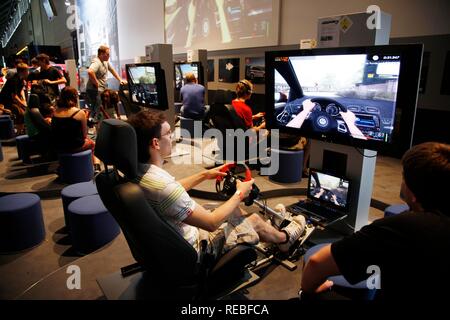 Simulatore di guida, giochi di auto, giochi di guida in corrispondenza della zona di intrattenimento del gamescom, il più grande del mondo per la fiera Foto Stock