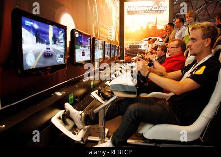 Simulatore di guida, giochi di auto, giochi di guida in corrispondenza della zona di intrattenimento del gamescom, il più grande del mondo per la fiera Foto Stock