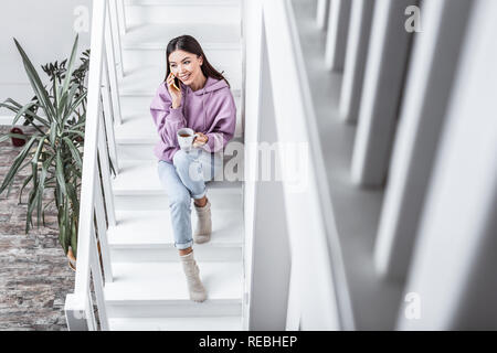 Sentimento donna riposato e alleviato bevendo tè a casa Foto Stock