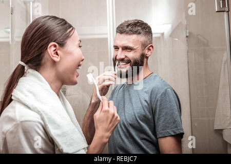 Carino ridere matura in lotta per il bagno al mattino Foto Stock