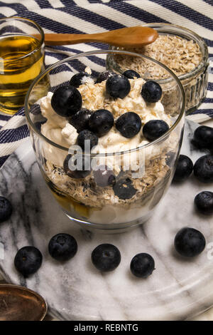 Cranachan, molto scottish dolce fatto con fiocchi di avena, mirtilli, il whisky e la panna montata in un bicchiere Foto Stock