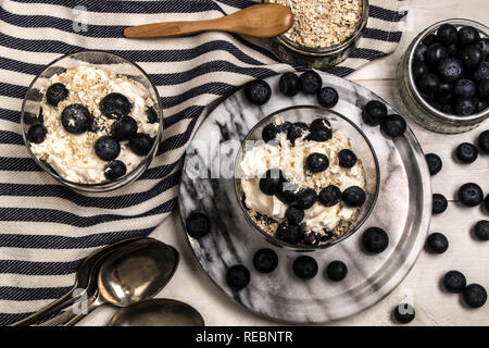 Cranachan, molto scottish dolce fatto con fiocchi di avena, mirtilli, il whisky e la panna montata in un bicchiere Foto Stock