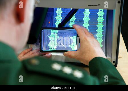 Ispezione di polizia, la convalida di documenti, i documenti dell'auto, utilizzando luce UV ed una lente di ingrandimento mobile della stazione di controllo della Foto Stock