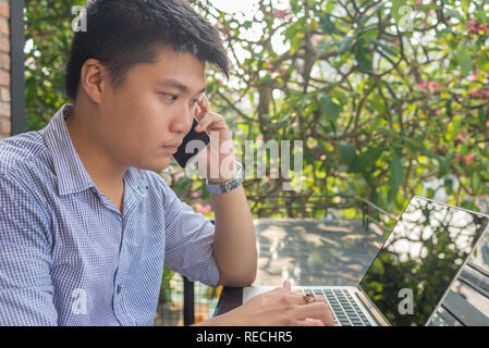 Gli investitori asiatici guardare il cambiamento del mercato azionario su laptop Foto Stock