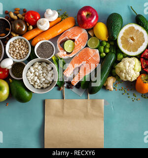 Sacchetto di carta con set cibo sano (cereali, semi, pesce, verdura e frutta) vista dall'alto. Lay piatto Foto Stock