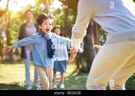 Asian little boy figlio in esecuzione verso l abbraccio del Padre. Foto Stock