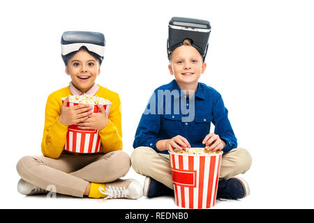 Stupito da studentessa con la realtà virtuale di cuffie sul capo azienda striped carton benna e il ragazzo mangiare popcorn isolato su bianco Foto Stock