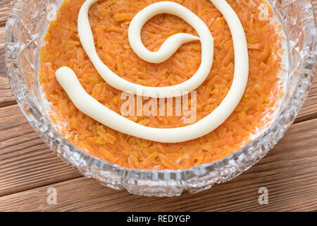 Il processo di cottura insalata di pesce Mimosa. La posa di carote e maionese Foto Stock