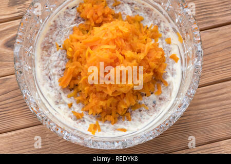 Il processo di cottura insalata di pesce Mimosa. La posa di carote e maionese Foto Stock