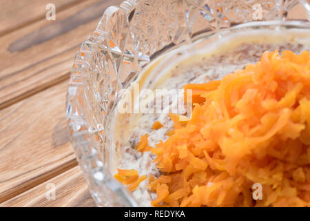 Il processo di cottura insalata di pesce Mimosa. La posa di carote e maionese Foto Stock