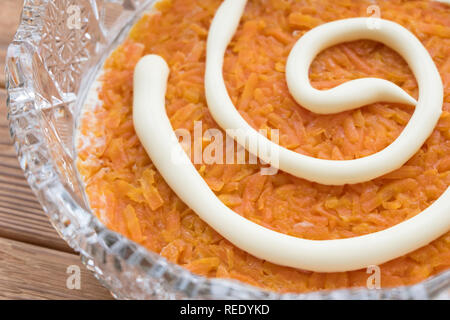 Il processo di cottura insalata di pesce Mimosa. La posa di carote e maionese Foto Stock
