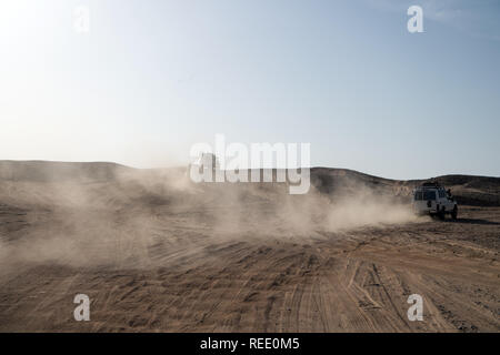 Concorrenza racing sfida deserto. Auto superare le dune di sabbia di ostacoli. Unità auto offroad con nuvole di polvere. Veicolo Offroad racing ostacoli nel deserto. Deserto interminabile. Gara di deserto di sabbia. Foto Stock