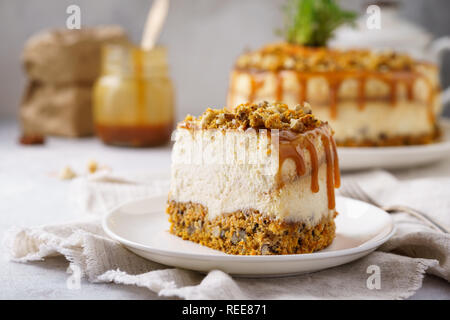 Pezzo di carota cheesecake con dadi e salati Topping Caramel. Pasqua o cadere il concetto di dessert. Foto Stock