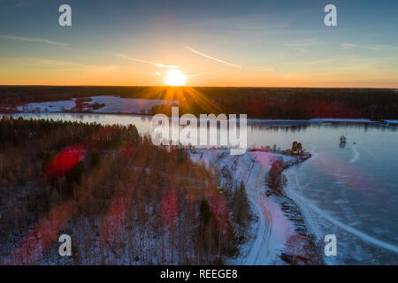 La bellissima natura e paesaggio al freddo inverno sera in Svezia Scandinavia Europa. Bel tramonto e ghiaccio congelato lago. Girato con drone da sopra Foto Stock