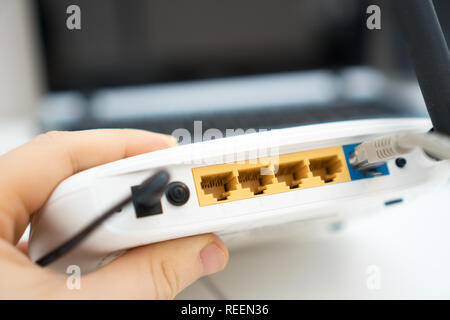 L'uomo bianco azienda wireless router nella sua mano. Foto Stock